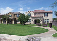 Exterior of two buildings at Henson Village with mission-style architecture and arched front porches, tile roofs and walking paths and wide lawns.